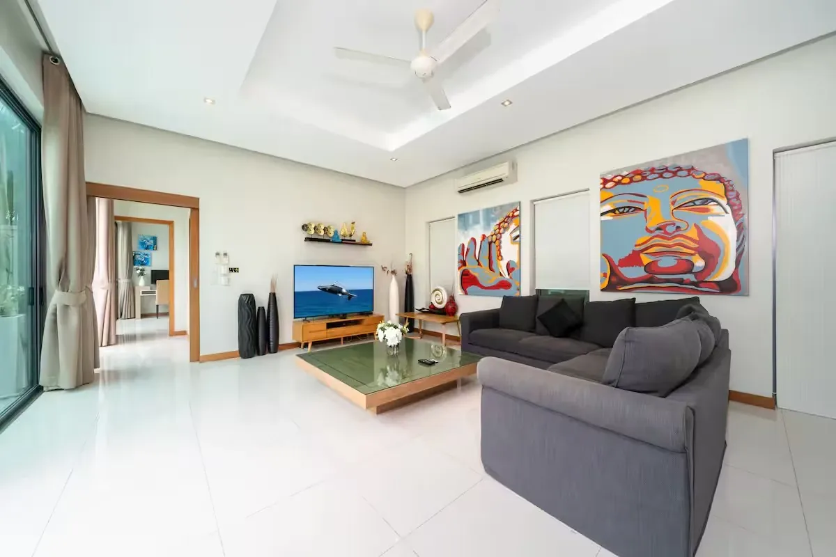 Baannaraya Villa, Най Харн — гостиная с панорамным остеклением и телевизором