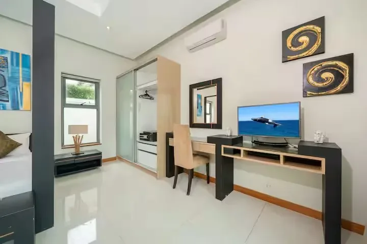 Baannaraya Villa, Най Харн — рабочий стол и телевизор в спальне