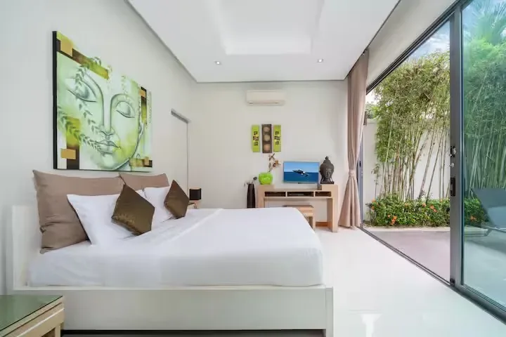 Baannaraya Villa, Най Харн — кровать у панорамной двери в сад