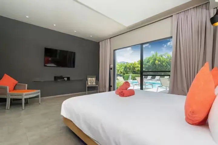 Mayacol Luxury Villa, Най Харн — спальня с телевизором и видом на бассейн