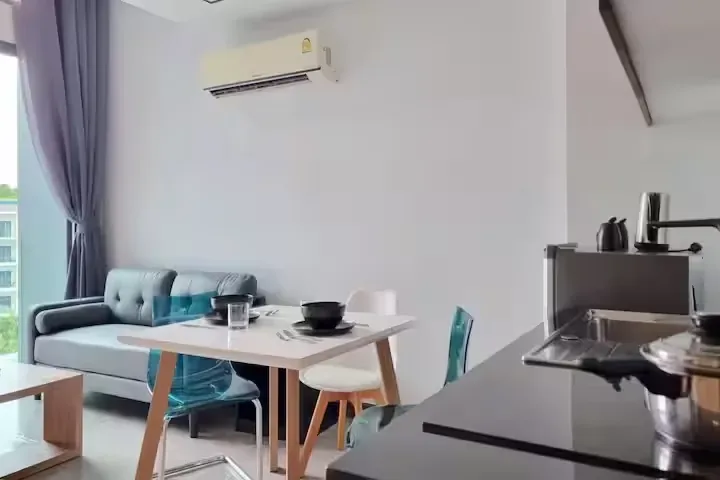 Pool View Duplex, Най Харн — гостиная с диваном и обеденным столом у кухни