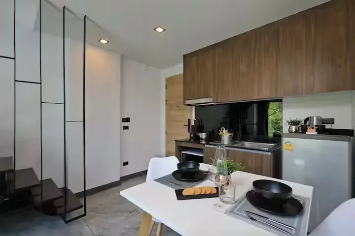 Pool Access Duplex, Най Харн — столовая с видом на кухню и лестницу