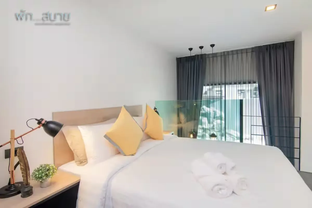 Pool Access Duplex, Най Харн — спальня с кроватью и жёлтыми подушками