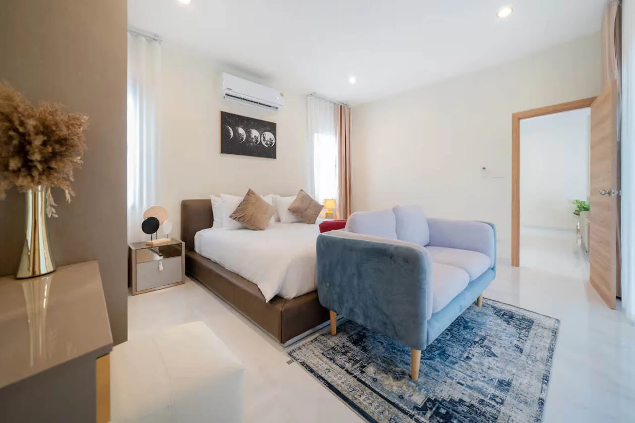 Rawai Stylish Pool Villa, Раваи — спальня с синим ковром и диваном у окна