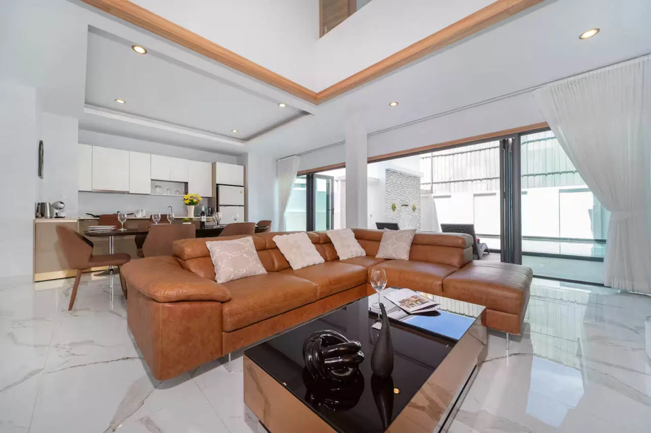 Villa Maple, Раваи — гостиная с кожаным диваном и кухней в глубине