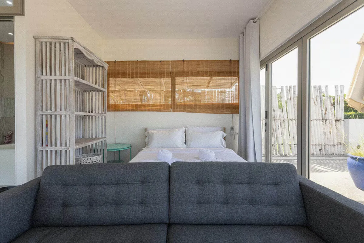 Sunset Beachfront Villa, Раваи — спальня с бамбуковым изголовьем и диваном