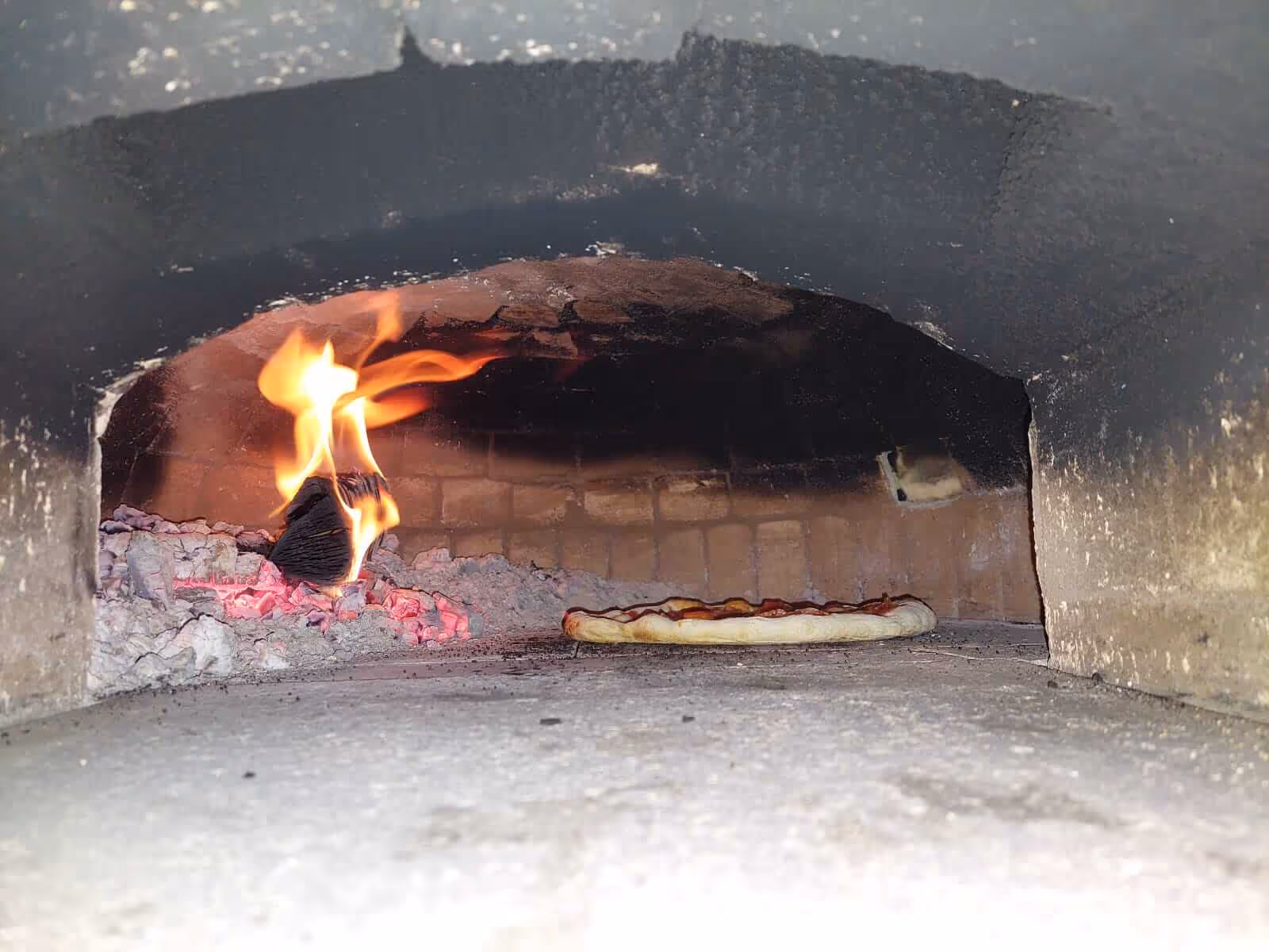Pizzaofen mit Feuer und Pizza