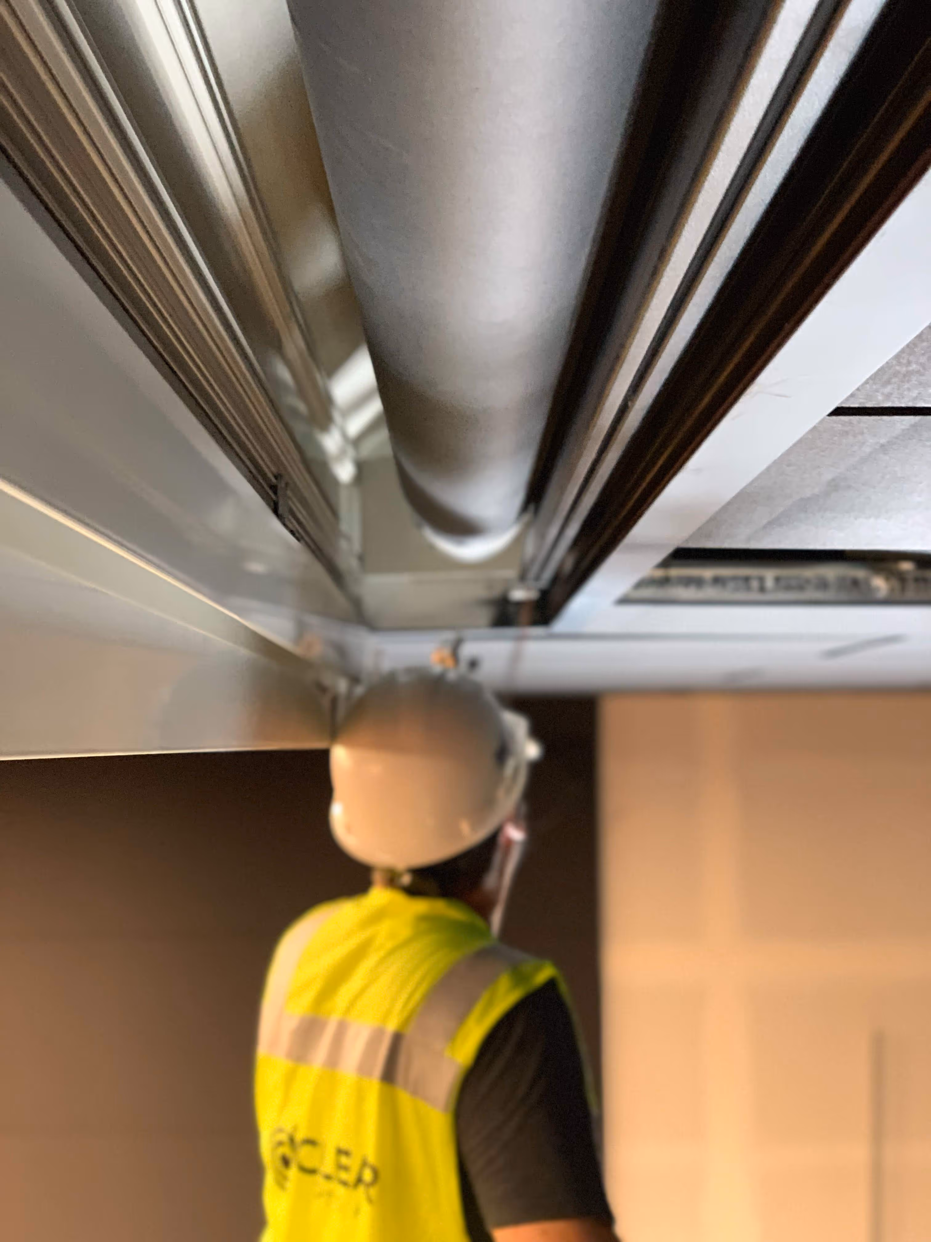 AV technician installing cabling and conduit on ceiling lift