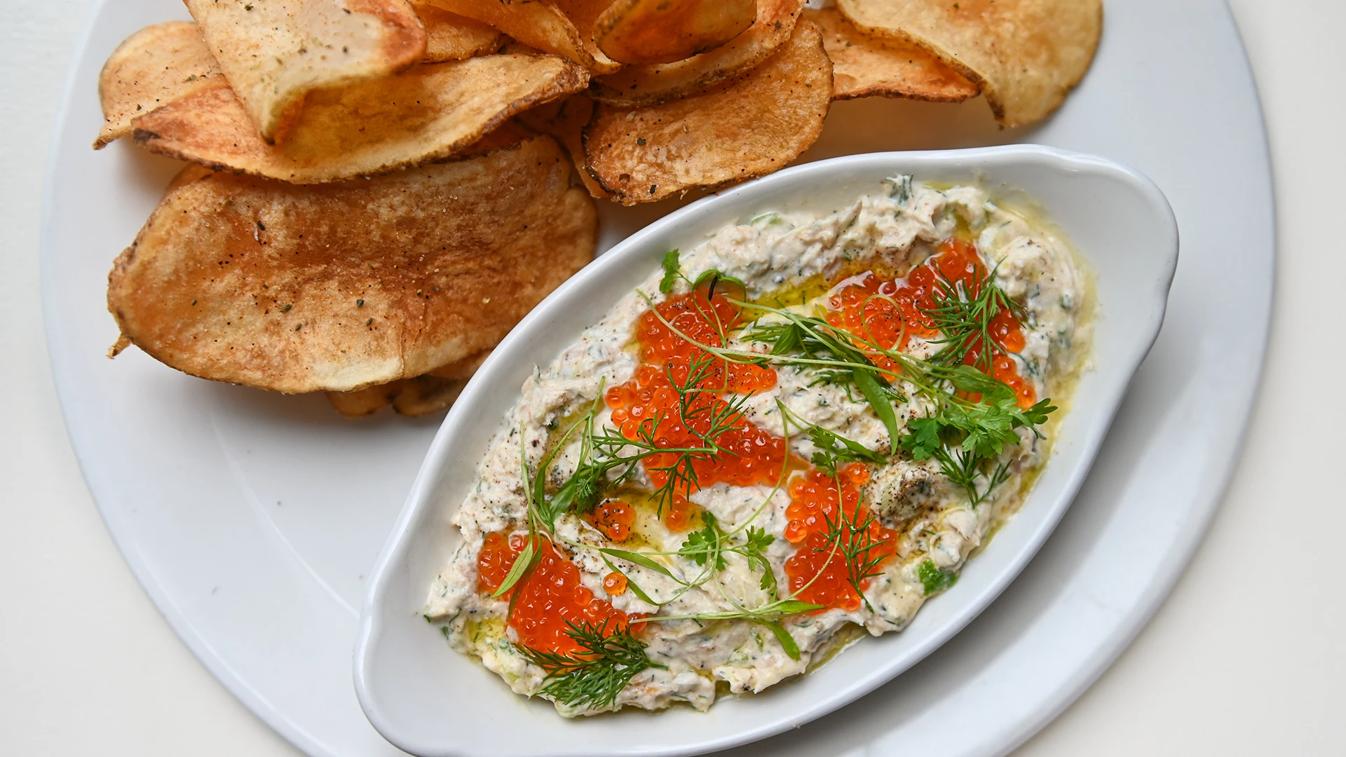 a dish with smoked trout dip and chips