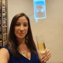 Avatar image of a woman in a black dress holding a champagne flute.