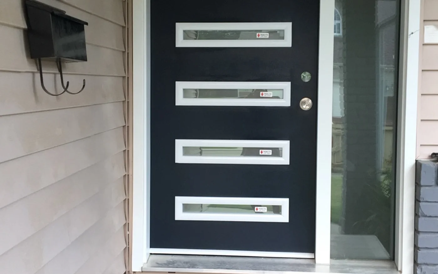 Modern black statement front door with horizontal glass panels in Edmonton