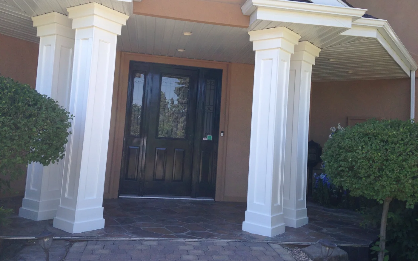 Finished white entry columns and dark double front door in Edmonton