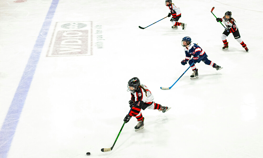 Image of a dad helping his son on the ice rink.