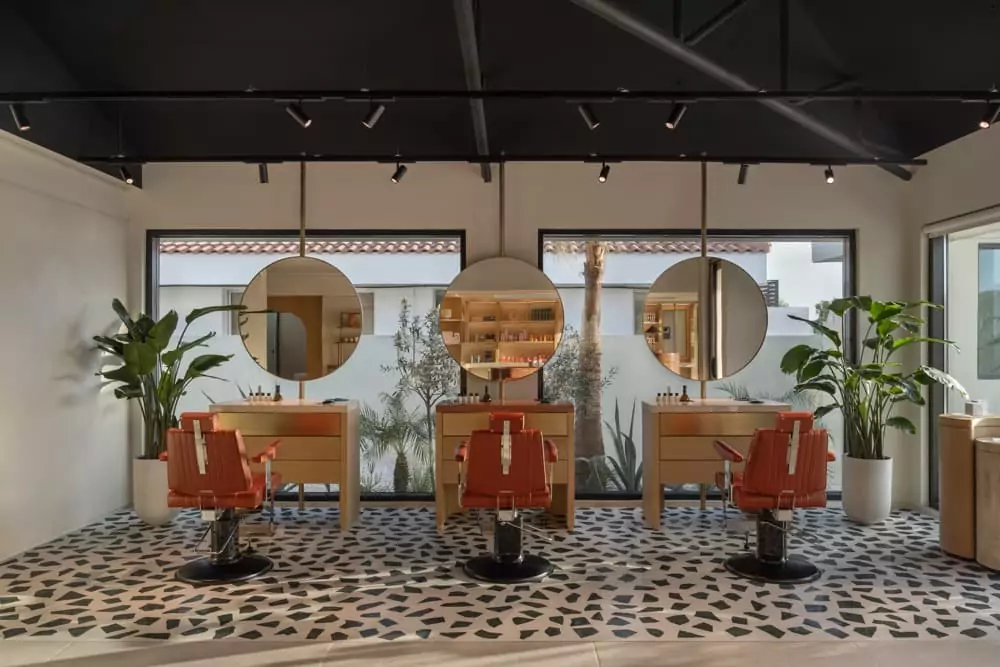 A room with a lot of chairs and mirrors.