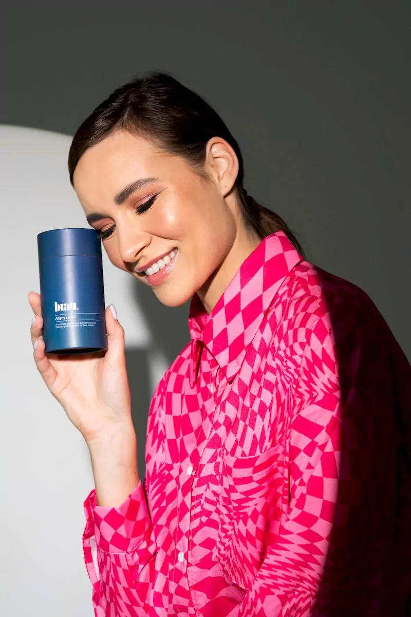 A woman in a pink shirt holding a blue mug.