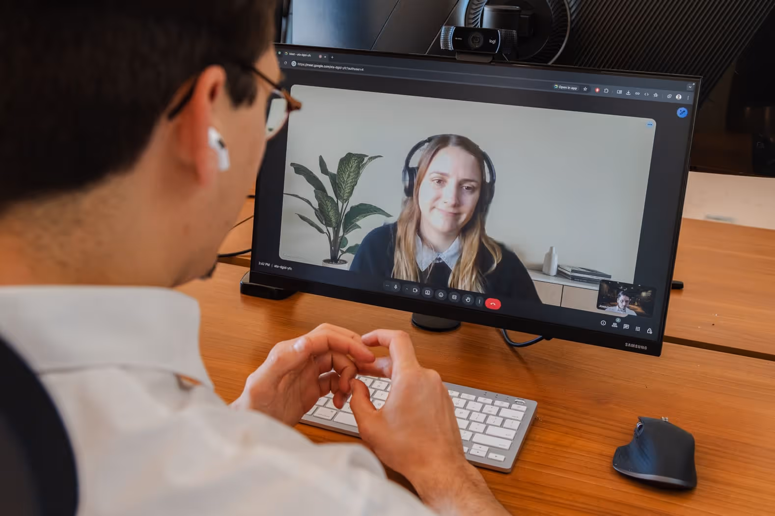 Edge Audio Labs team member participating in a remote video call, collaborating with a colleague on screen who is wearing professional headphones, demonstrating the company's focus on teamwork and remote communication in audio development.