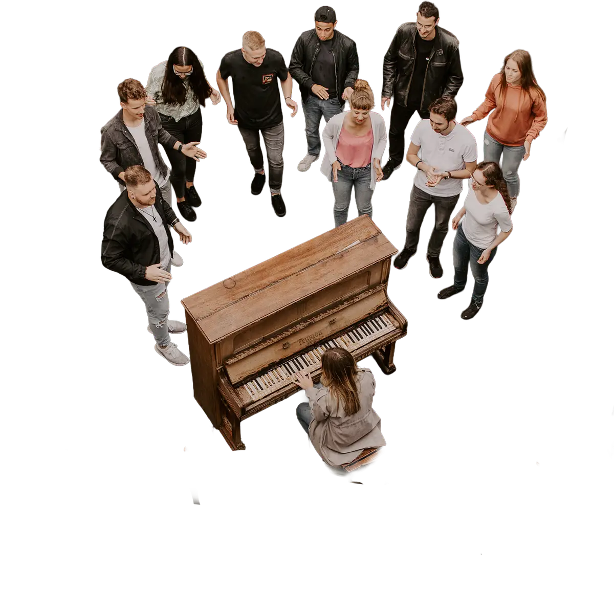 Gruppe von jungen Menschen die um ein altes Klavier versammelt sind