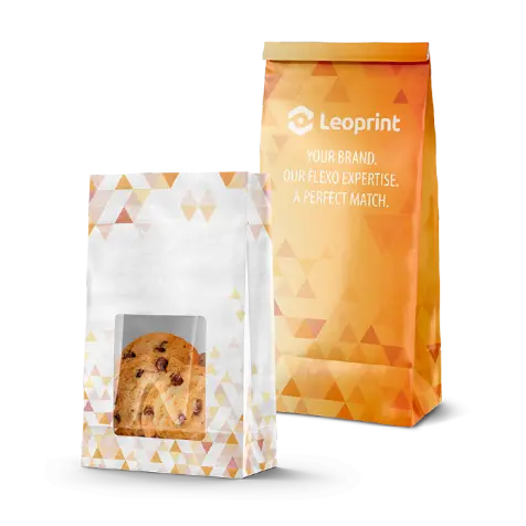 Two packaging bags with geometric patterns; one transparent holding a chocolate chip cookie, and one orange with Leoprint branding and slogan.