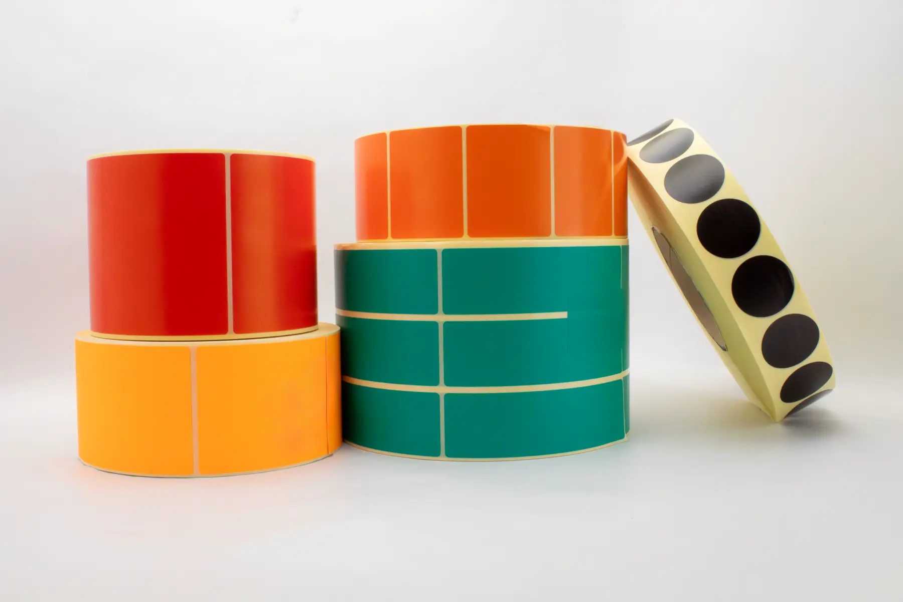 Color-coded thermal transfer rolls for inventory logistics, manufactured with consistent caliper control to ensure stable runnability in industrial Zebra/Sato printers.