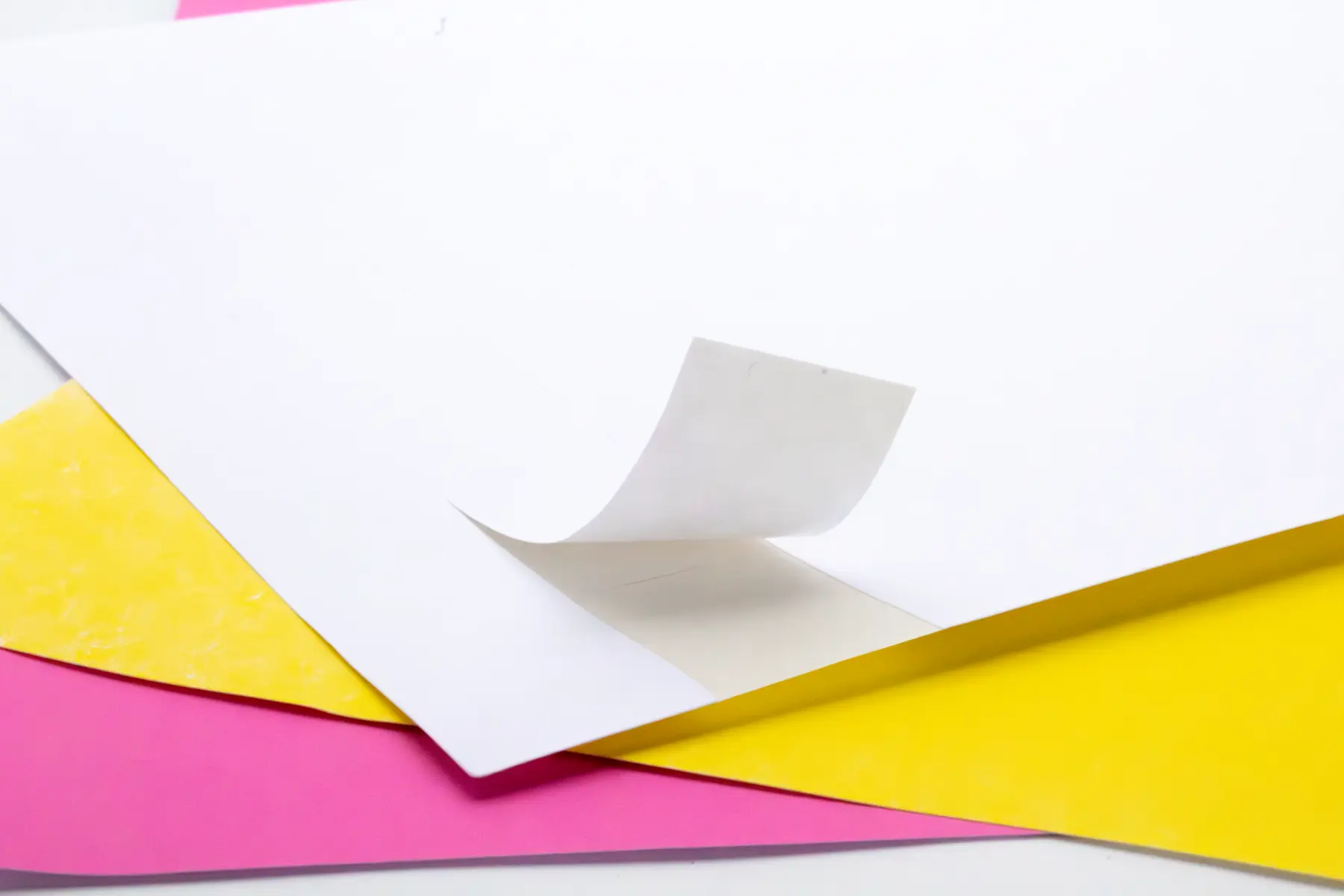 Close-up of aggressive hot-melt adhesive performance, engineered for instant high-tack bonding on low-energy surfaces like rough cardboard or shrink wrap.