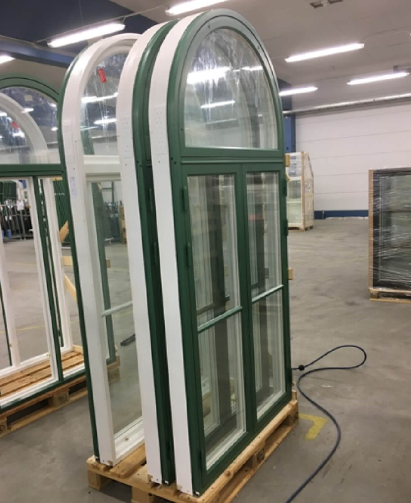 Reclaimed arched glass doors at reuse hub – materials ready for resale via Enke marketplace