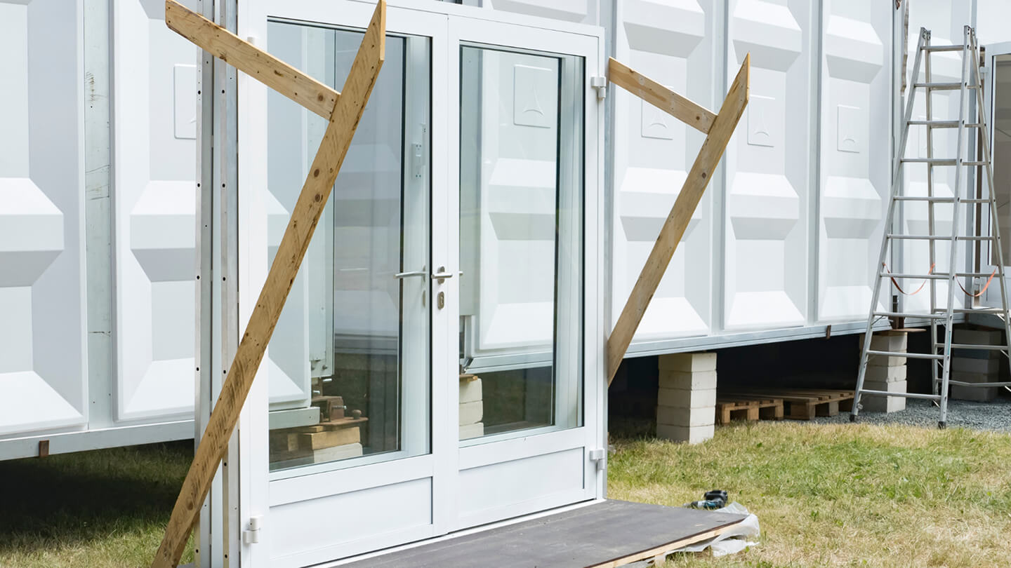 Reused white door and glass window frame on construction site – showcasing circular construction with Enke platform
