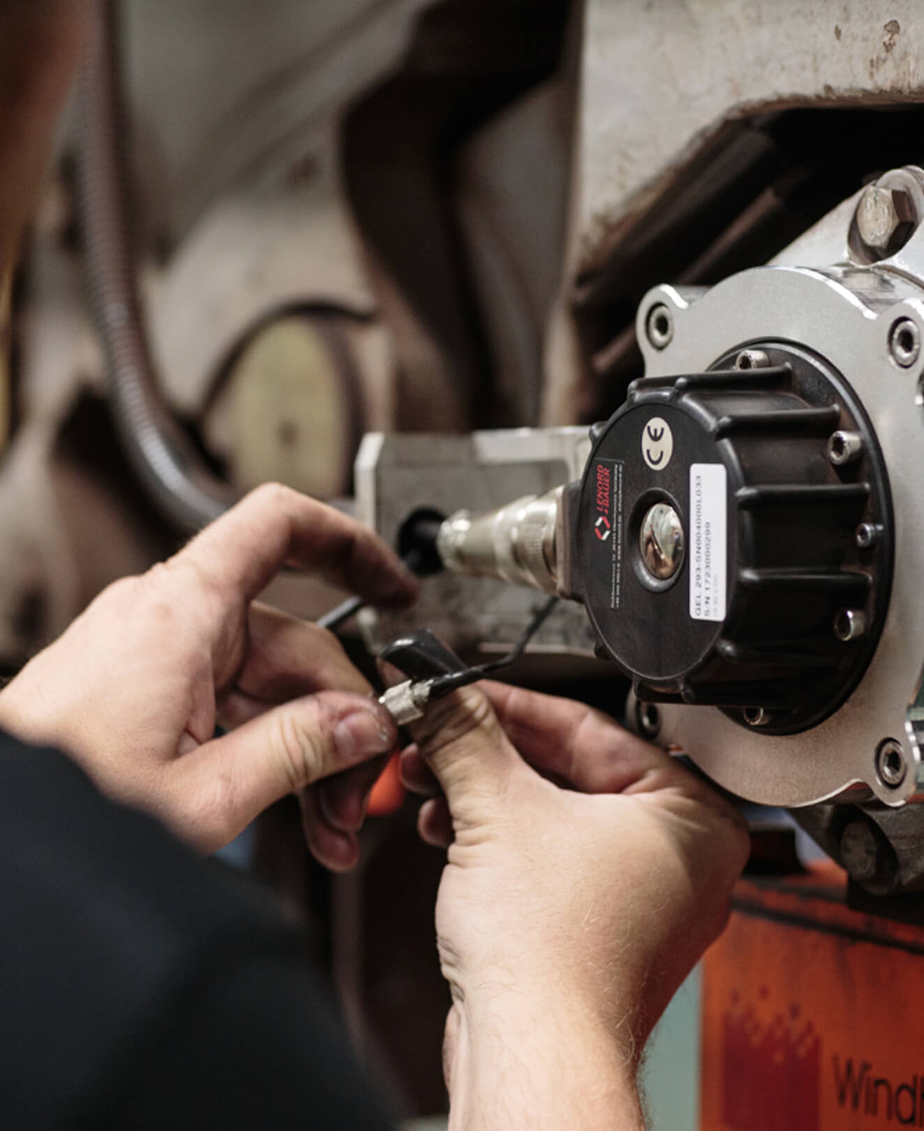 Technician's hand placing sensor on railway component – real-time data collection with QTMS