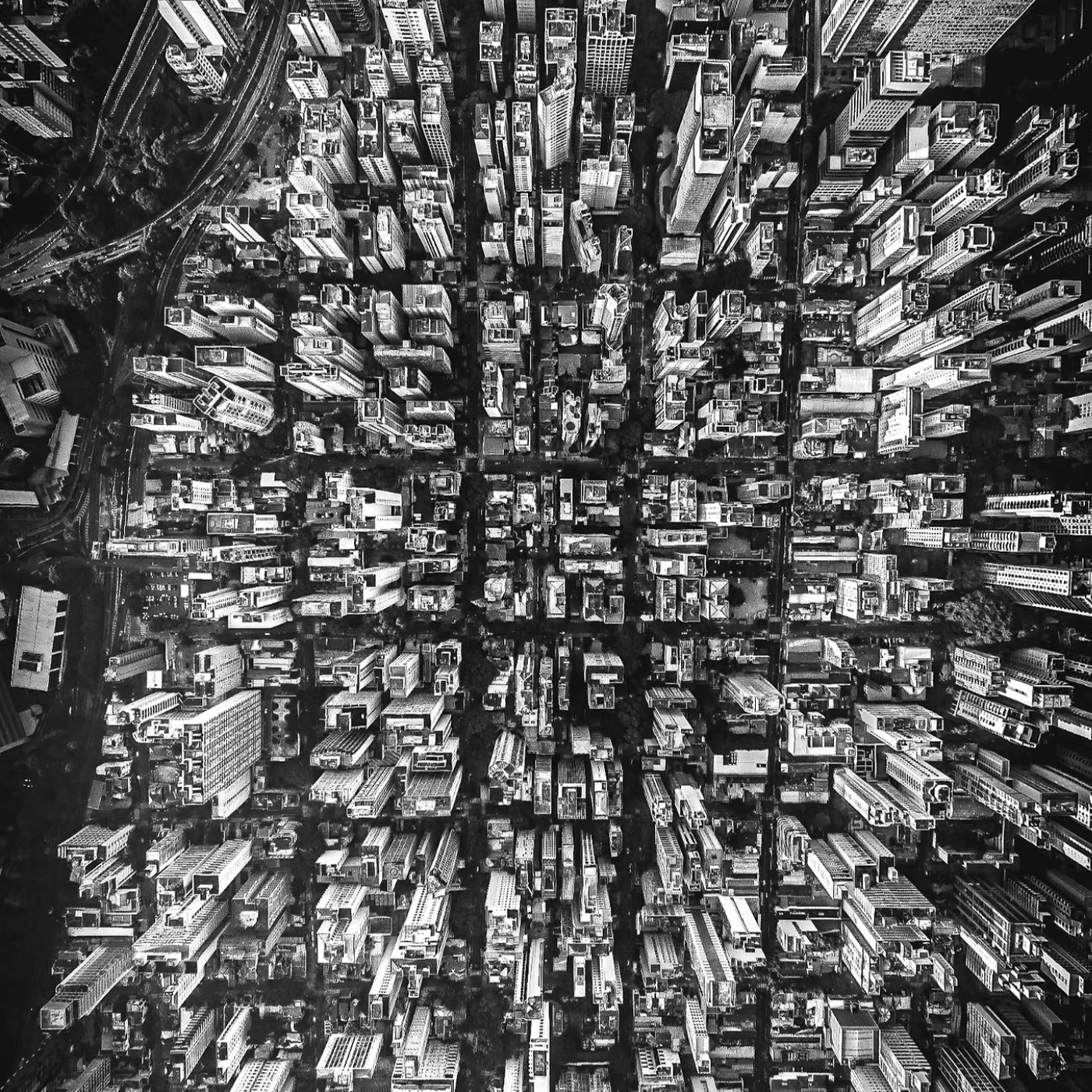 Aerial black and white view of a dense cityscape filled with skyscrapers and streets, symbolizing scale, structure, and the complexity of modern business environments.