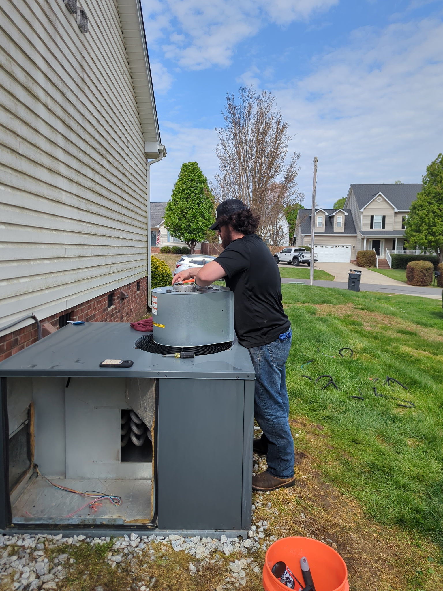 White outdoor heat pump unit with front grill.