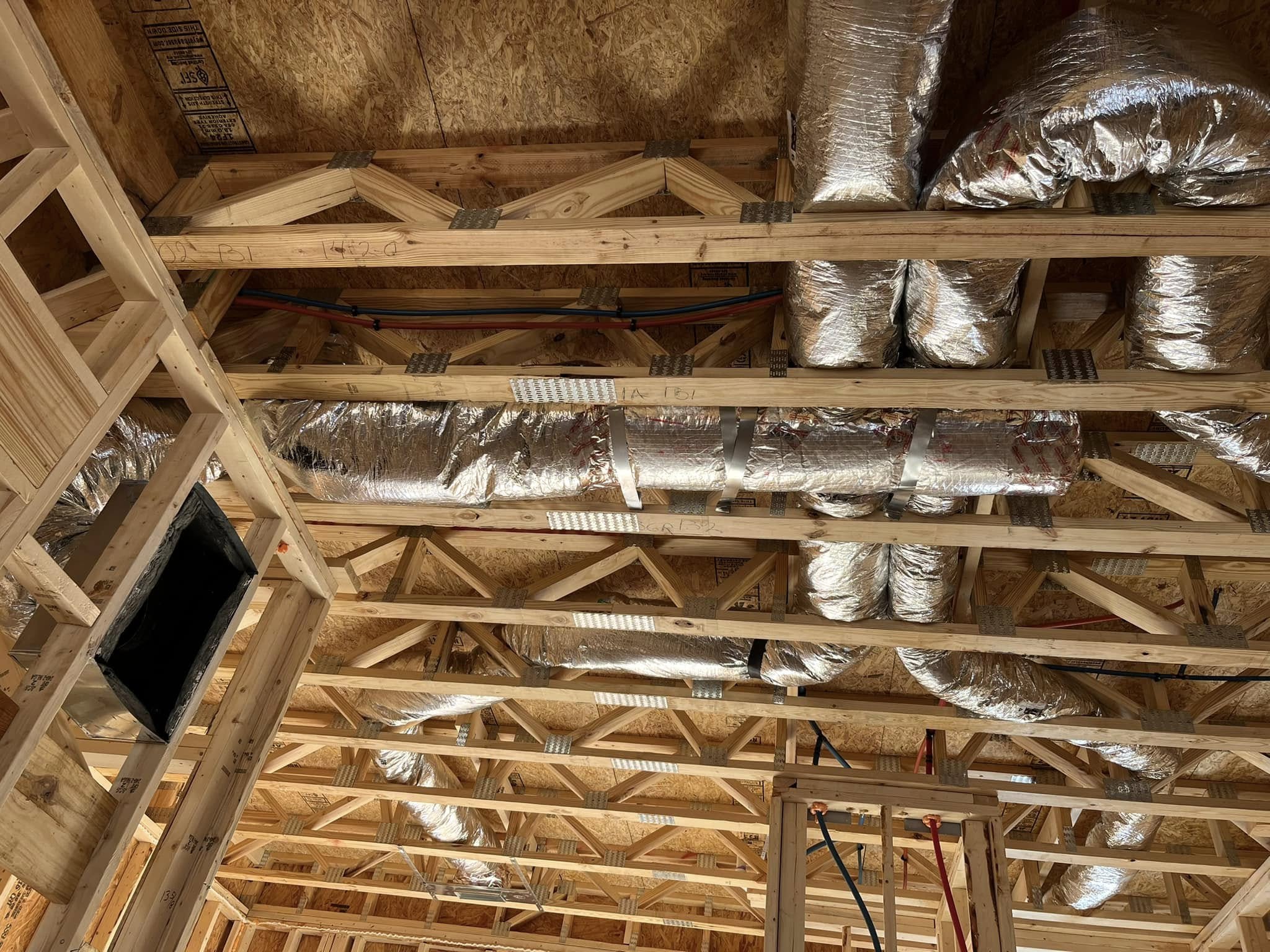Technicians installing air ducts in new home construction