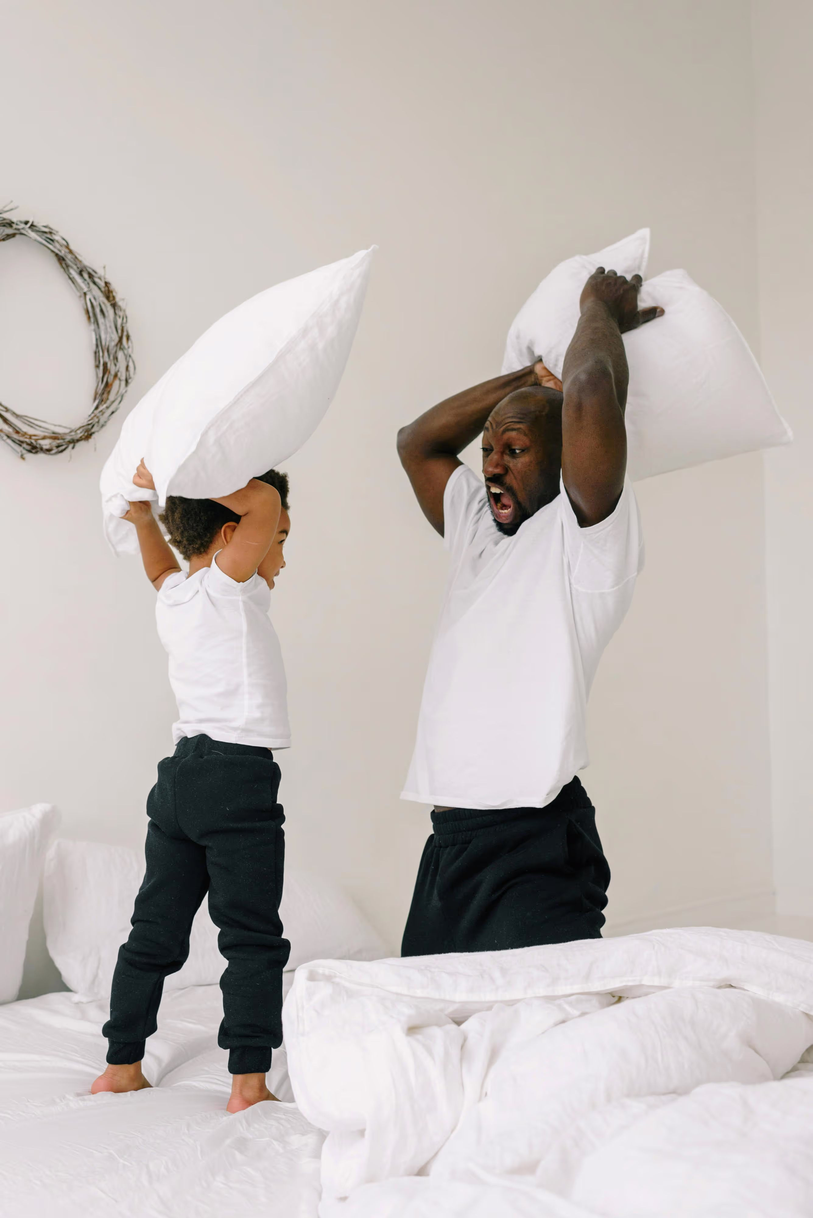 Father and son having a pillow fight together.