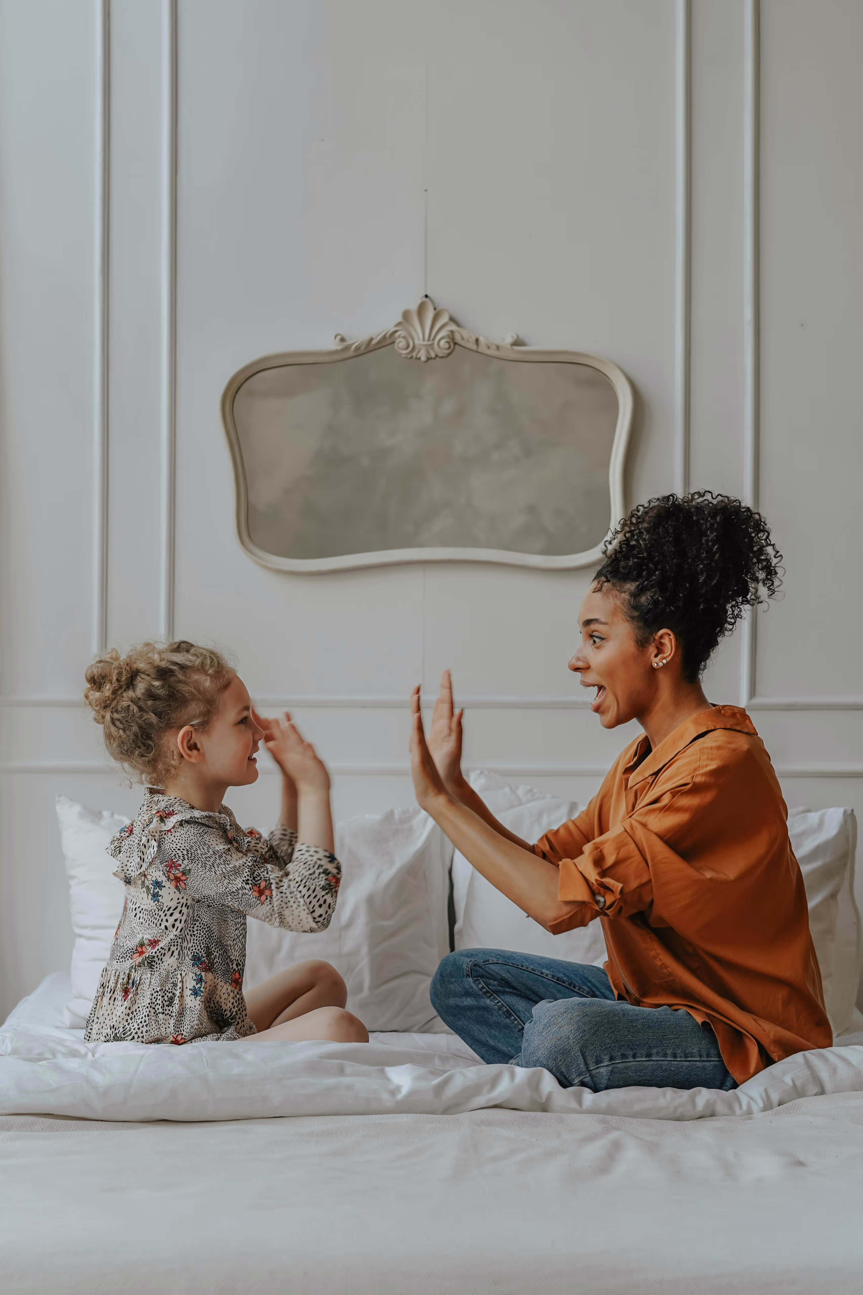 A mother and daughter playing games together on their mattress.