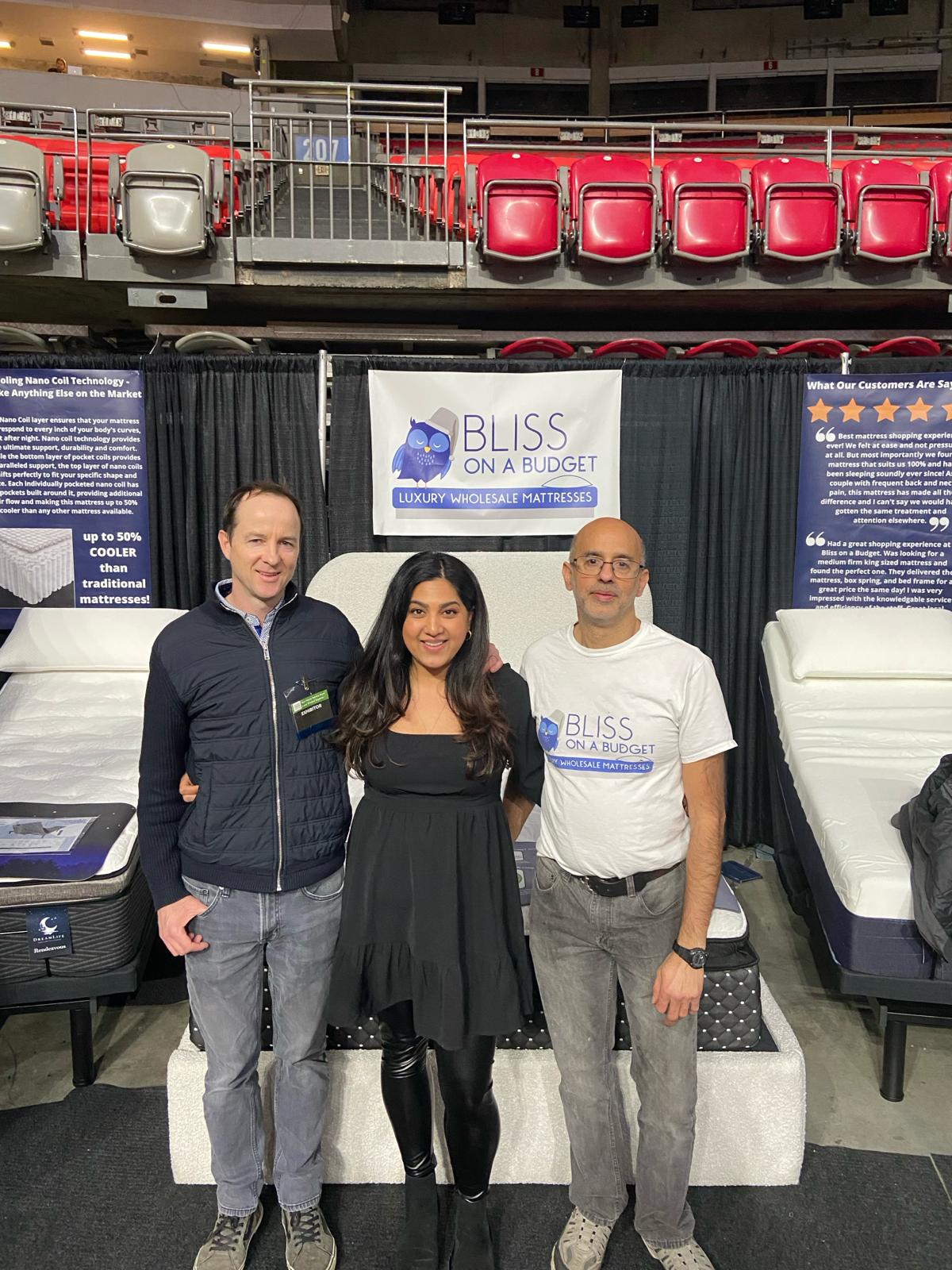 The Bliss team posing for a photo in front of a mattress.