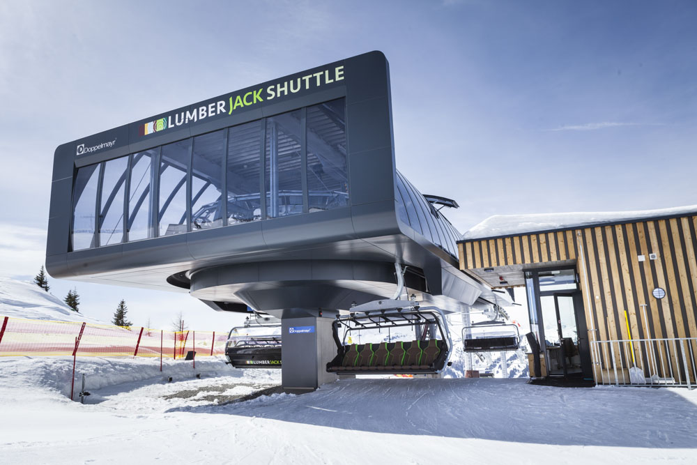 Modernes Stationsgebäude der Sesselbahn „Lumberjack Shuttle“ von Doppelmayr mit verglaster Front und Holzfassade im Skigebiet