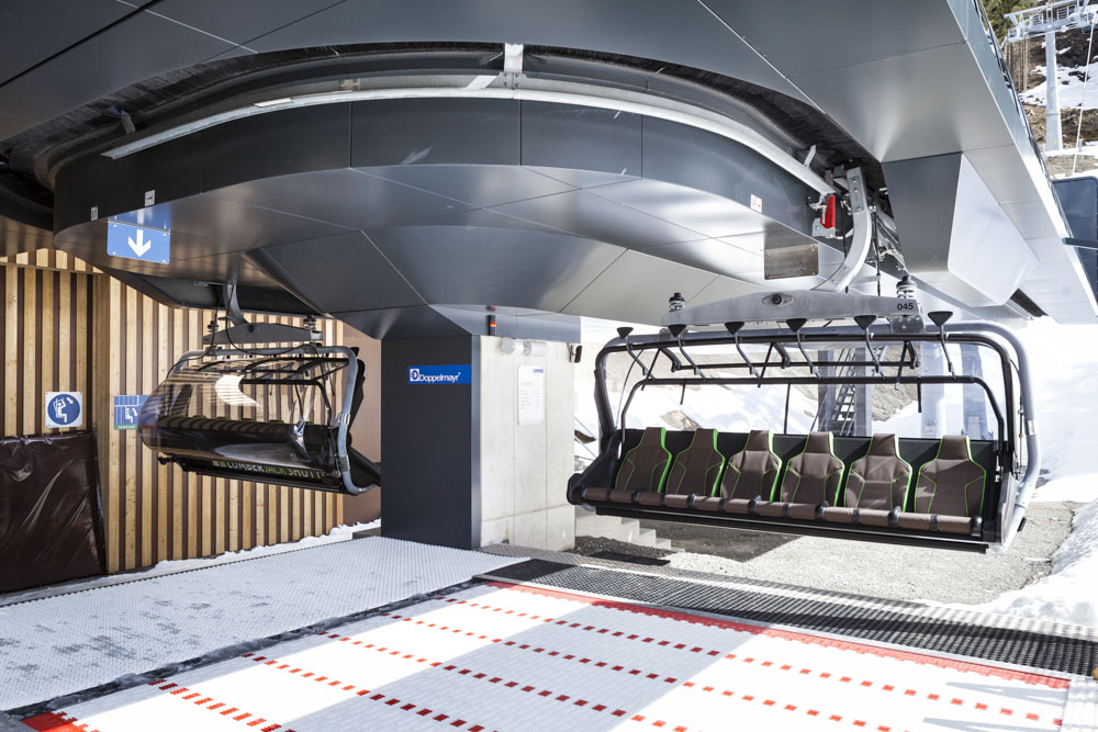 Sessel mit grüner Polsterung und Wetterschutzhaube in der Umlaufstation der Lumberjack Shuttle Bahn von Doppelmayr