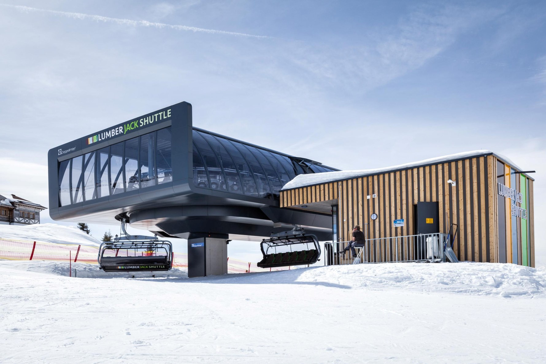 Modernes Stationsgebäude der Sesselbahn „Lumberjack Shuttle“ von Doppelmayr mit verglaster Front und Holzfassade im Skigebiet