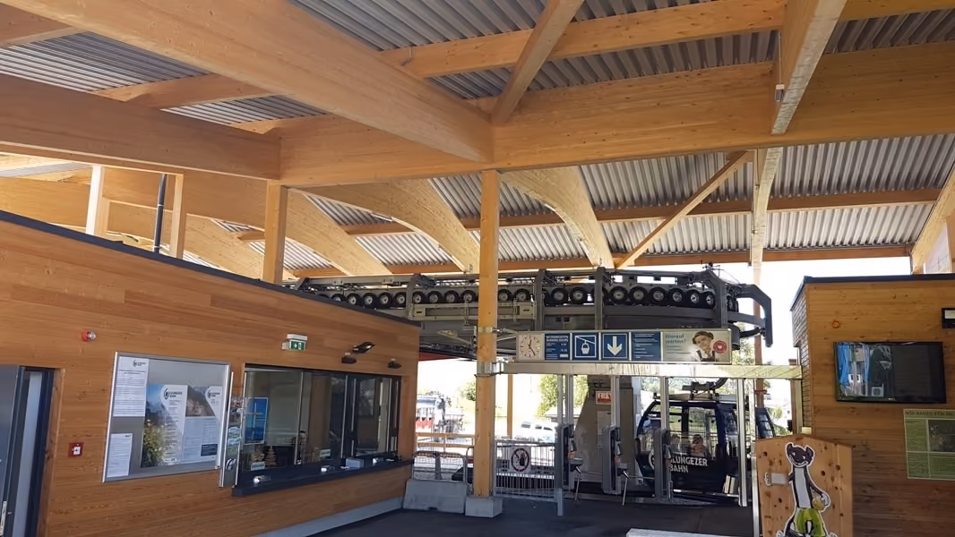Heller Innenbereich der Talstation mit Holzdecke und Zugang zur Gondel