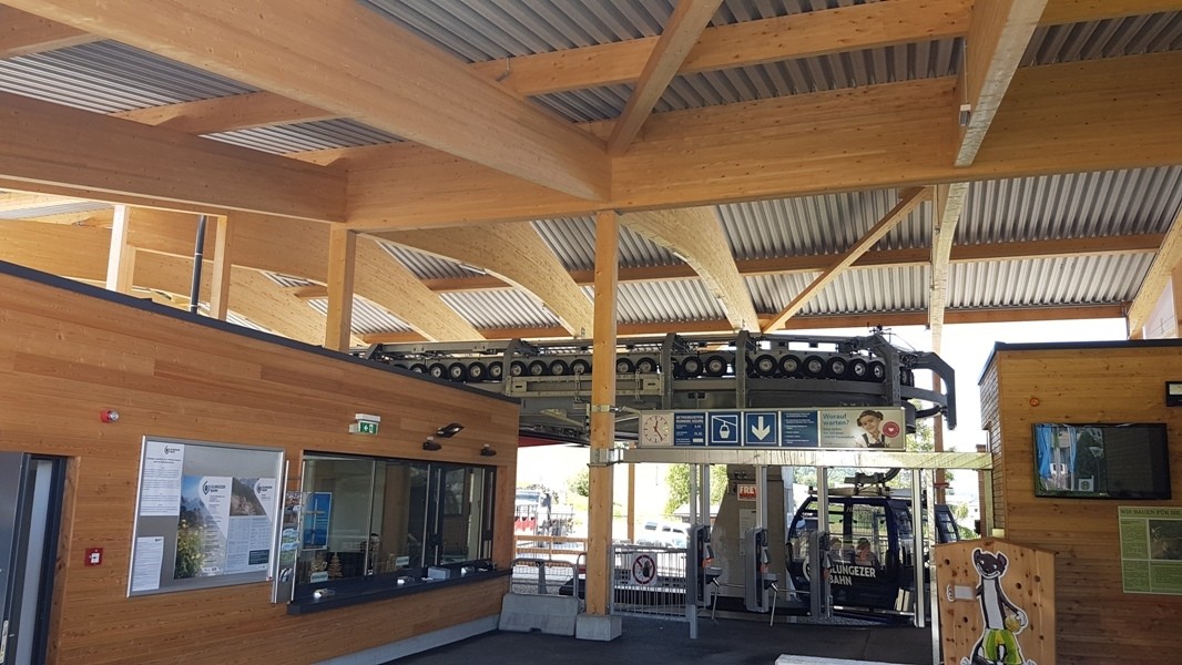 Heller Innenbereich der Talstation mit Holzdecke und Zugang zur Gondel
