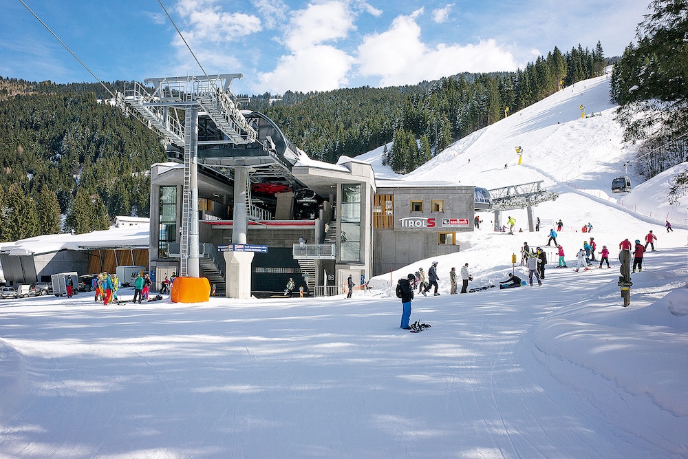 Vierstadlalm-Talstation in Fieberbrunn mit Skifahrern im Winter
