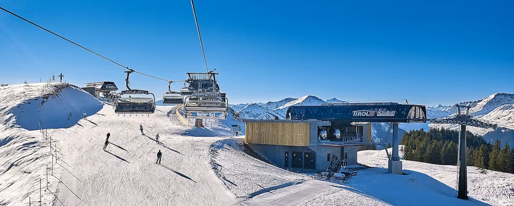 Sessellift Reiter Ost bei der TirolS-Bergstation mit Skifahrern.