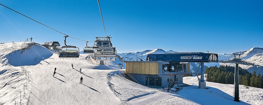 Sessellift Reiter Ost bei der TirolS-Bergstation mit Skifahrern.