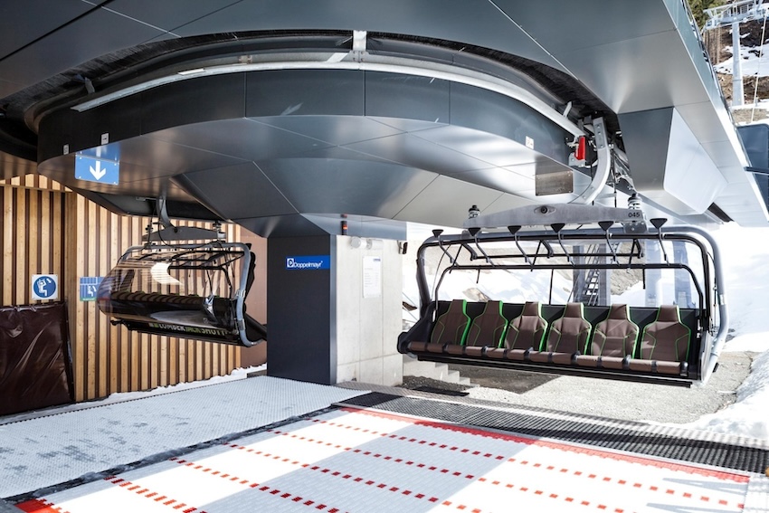 Sessel mit grüner Polsterung und Wetterschutzhaube in der Umlaufstation der Lumberjack Shuttle Bahn von Doppelmayr