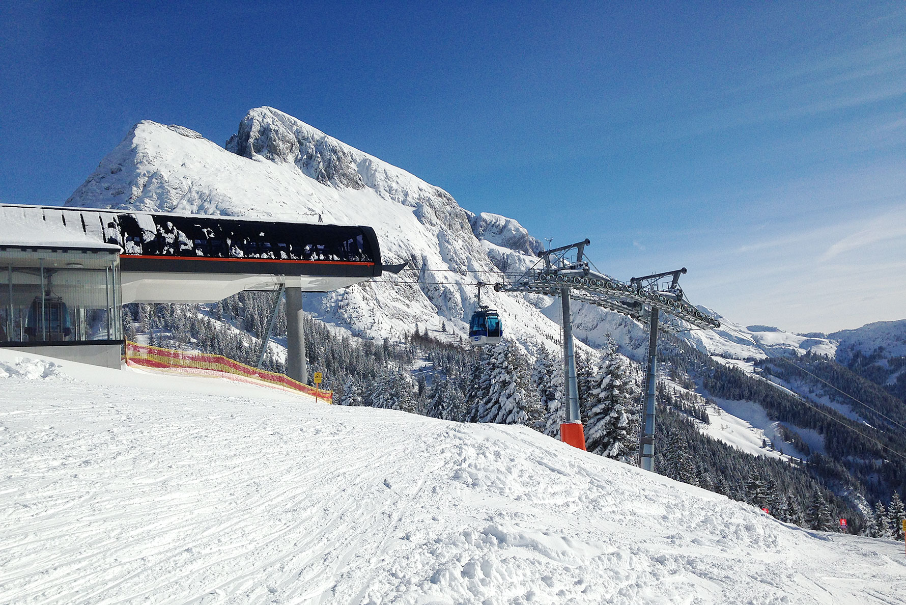 Bergstation mit Gondelbahn und markantem Gipfel im Hintergrund