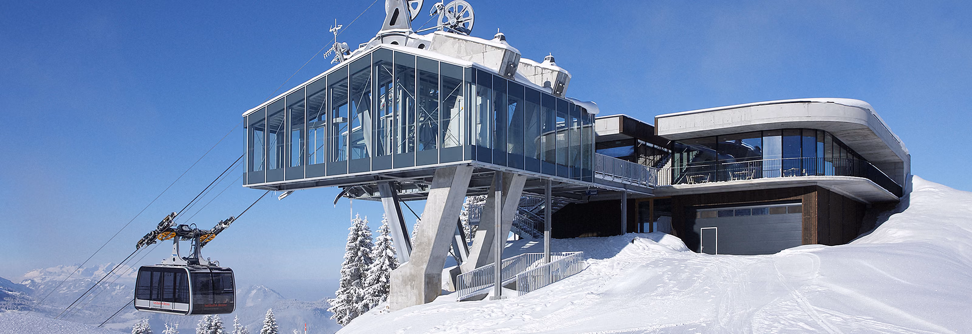 Bergstation der Seilbahn Bezau mit gläsernem Anbau im verschneiten WinterpanoramaBergstation der Seilbahn Bezau mit gläsernem Anbau im verschneiten Winterpanorama