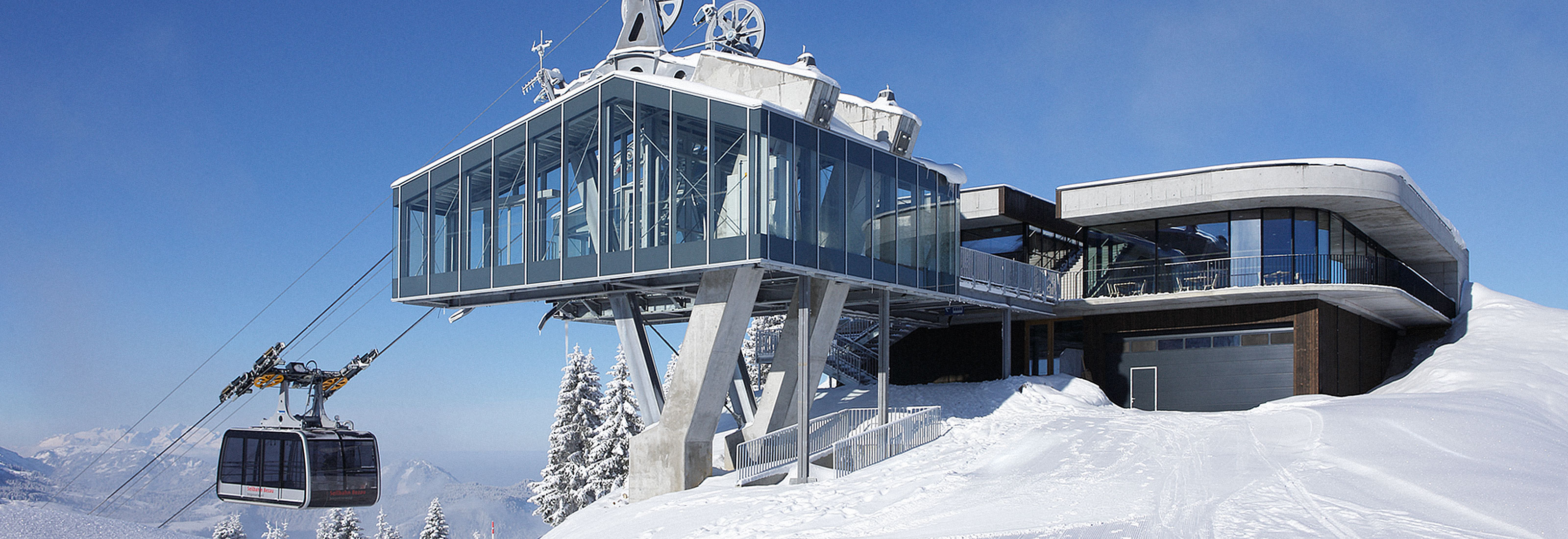 Bergstation der Seilbahn Bezau mit gläsernem Anbau im verschneiten WinterpanoramaBergstation der Seilbahn Bezau mit gläsernem Anbau im verschneiten Winterpanorama