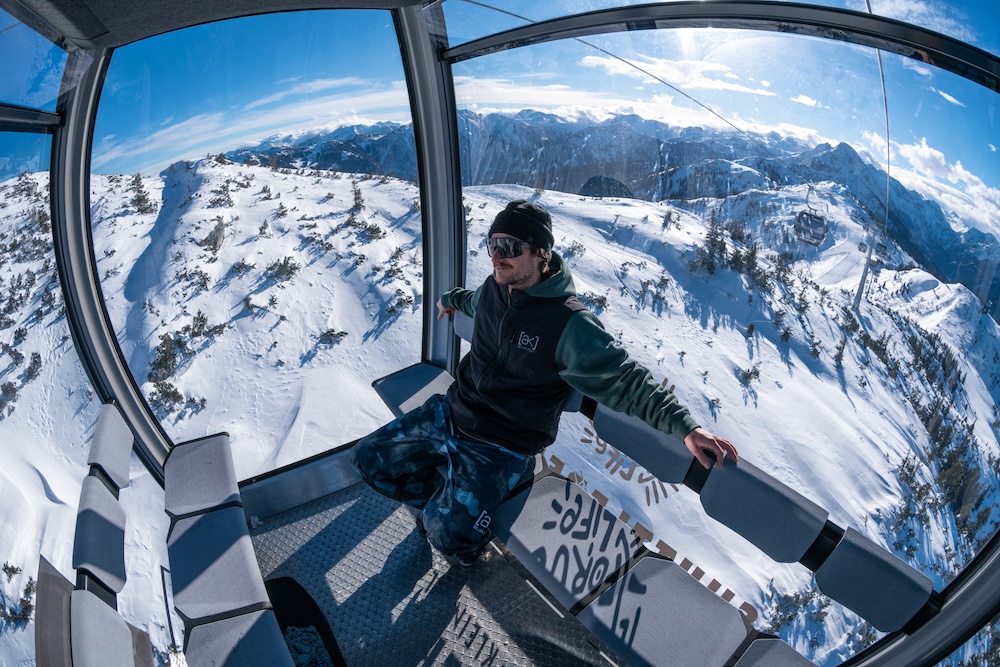 Wintersportler in Panoramagondel mit Blick auf verschneite Berglandschaft