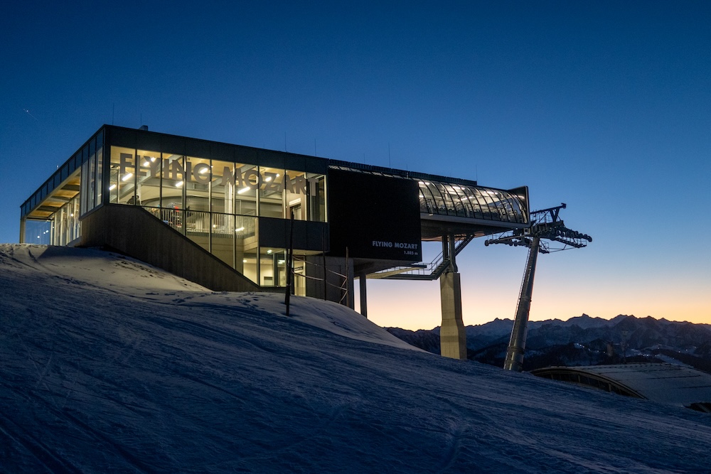 Flying Mozart Bergstation bei Sonnenuntergang mit beleuchtetem Innenraum