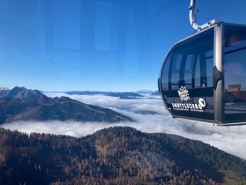 Shuttleberg Gondel über wolkenverhüllter Herbstlandschaft mit Bergkulisse