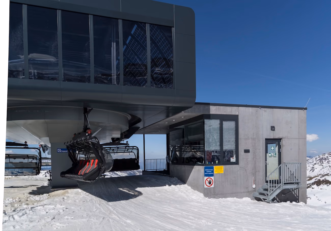 Sessellift-Bergstation mit Technikgebäude auf schneebedecktem Plateau