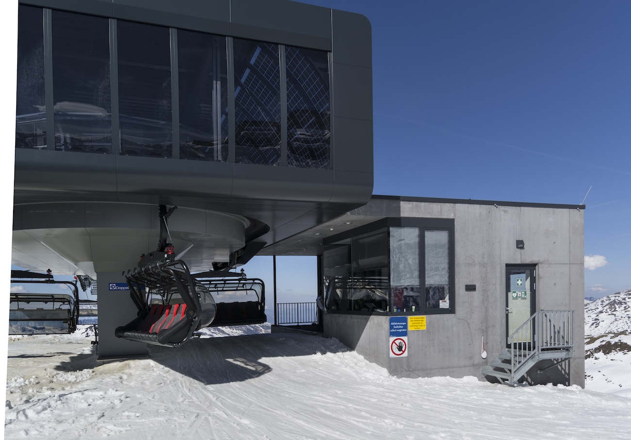 Sessellift-Bergstation mit Technikgebäude auf schneebedecktem Plateau